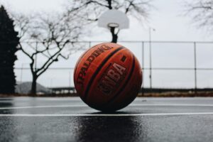 A basketball sitting on wet pavement