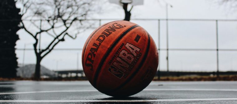 A basketball sitting on wet pavement